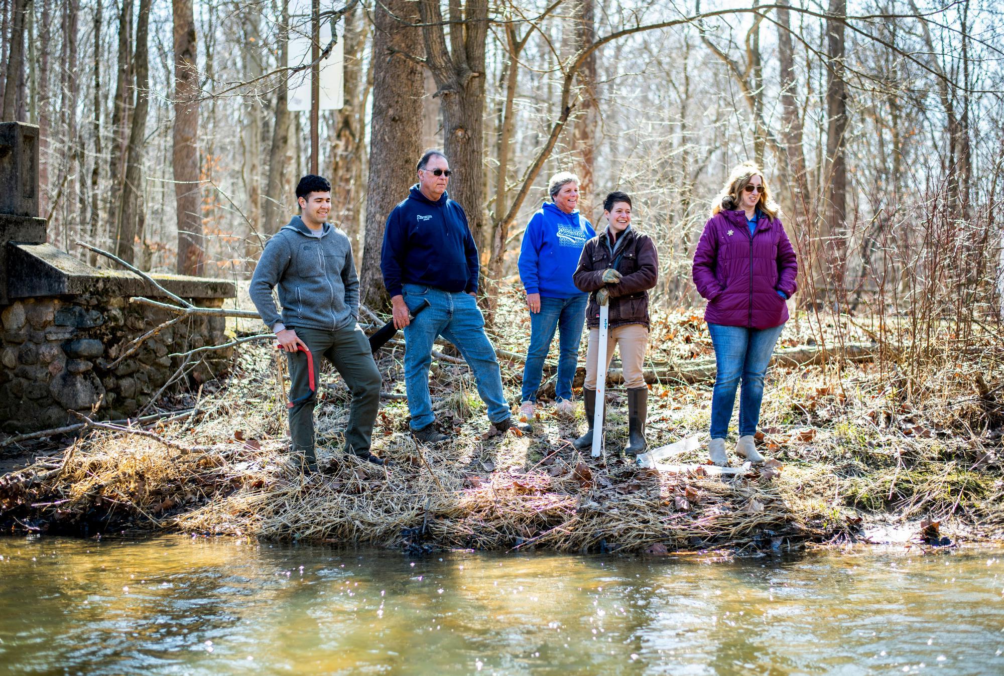 Students at the edge of a creek with a profession